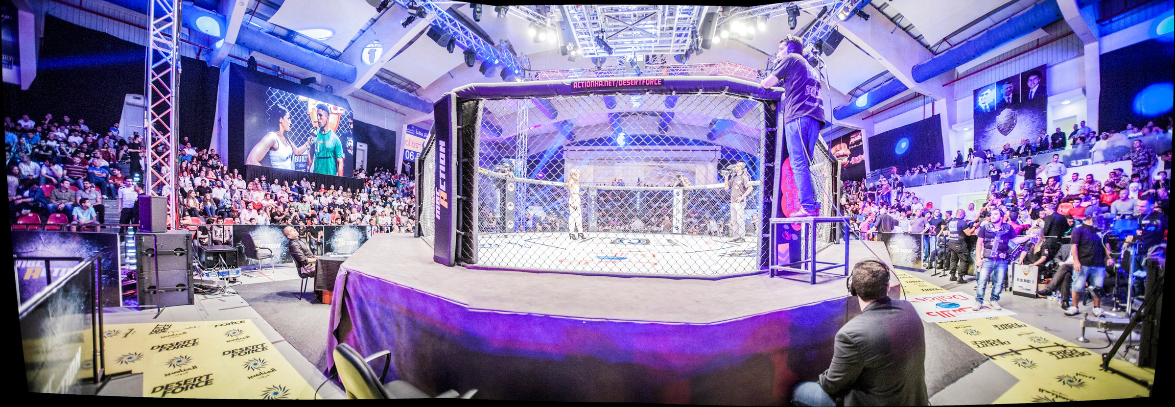 A packed Desert Force arena, the cage lit at the centre of a full house.